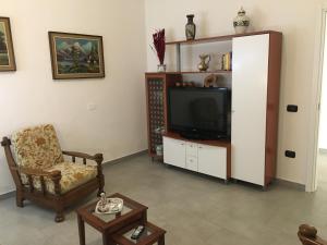 ein Wohnzimmer mit einem TV und einem Stuhl in der Unterkunft Casa jole in Assemini
