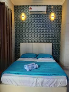 ein Schlafzimmer mit einem Bett mit einer blauen Decke in der Unterkunft GekQ Inn Langkawi in Pantai Cenang