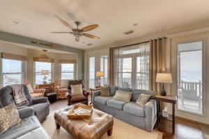 een woonkamer met een bank, stoelen en ramen bij Folly 'B' Golly in Folly Beach