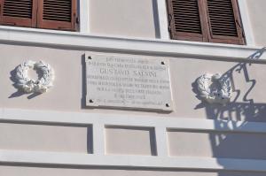 ein Schild an der Seite eines Gebäudes mit Blumen darauf in der Unterkunft Villa Salvini in Marina di Pisa