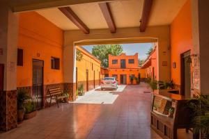 an entrance to a building with a car parked in the street at Hotel Cuauhtemoc in Querétaro