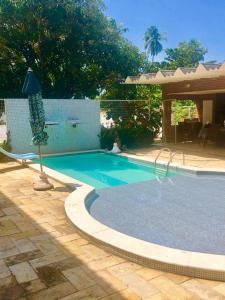 una piscina en un patio junto a una casa en Pousada Praia da Barra, en Barra de São Miguel