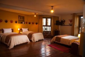 a room with two beds and a television in a room at Eureka San Blas in Cusco