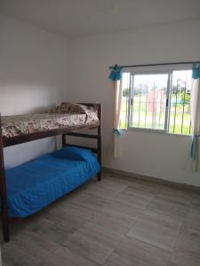 a bedroom with two bunk beds and a window at Quijaneando in Campo Quijano