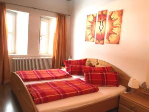 バート・ヒンデラングにあるHoliday @ Bad Hindelangのベッドルーム1室(赤い枕のベッド2台付)