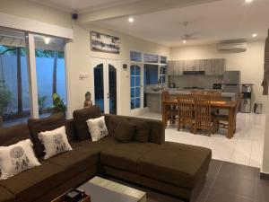 a living room with a couch and a kitchen at Alinta Villa 1 in Sanur