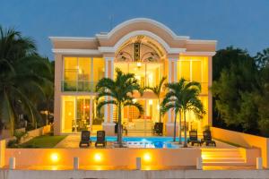 a large house with a swimming pool in front of it at Hermosa Mansión en Puerto Aventuras con alberca in Puerto Aventuras +27 photos