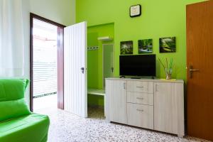a living room with a flat screen tv on a cabinet at Angelsa Casa Vacanze in Marina di Modica