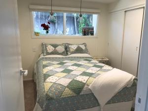 a bedroom with a bed with a quilt and a window at Villa @23 in Wanaka