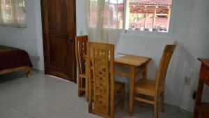 a table and chairs in a room with a window at Pie de Playa la Ropa in Zihuatanejo