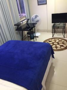 Un dormitorio con una cama azul y un piano en Apartamento em Ponto Estratégico do Bairro de Botafogo, Espaço inteiro, Andar Alto, Vista Frontal Para o Pão de Açúcar e Baía de Guanabara, Ar-Condicionado SPLIT 24000 BTU's, 3 minutos a Pé da Estação do Metrô e Wi-Fi gratuito, en Río de Janeiro