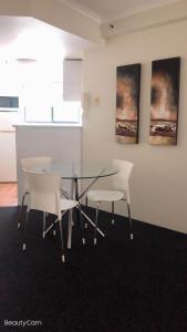 a room with a table, chairs, and a painting on the wall at Windsurfer Resort in Gold Coast