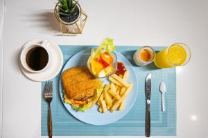 a plate with a sandwich and french fries and a cup of coffee at 墾丁南灣Relaxury旅浪沙戀民宿 in Nanwan