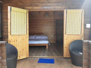 ein Schlafzimmer mit einem Bett in einer Holzhütte in der Unterkunft Cocorico Stay Ya! Cottages Alibag in Alibag