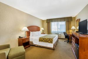 a hotel room with a bed and a flat screen tv at Baymont by Wyndham Fort Morgan in Fort Morgan