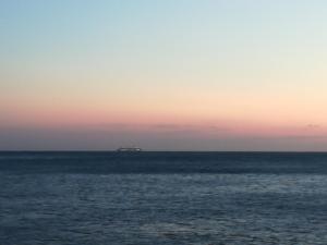 a ship in the ocean at sunset at Private Room in Beautiful Home in Montevideo