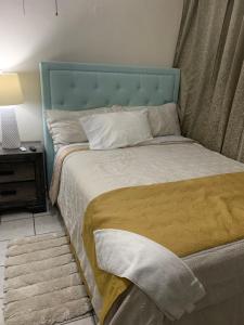 uma cama com uma cabeceira azul num quarto em Natural Village #1,2,3 & 5 em San Juan