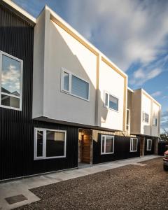 une maison à la façade noire et blanche dans l'établissement Etnias Apartments, à Puerto Natales