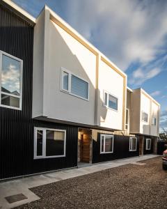 a house with a black and white facade at Etnias Apartments in Puerto Natales
