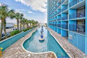 a water ride in a pool next to a building at Lee's Myrtle Beach Condo in Myrtle Beach