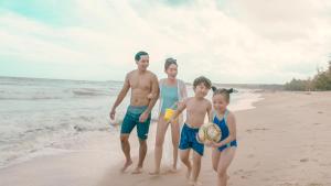 a family is standing on the beach at Seava Ho Tram Beach Resort in Ho Coc