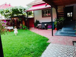 una niña caminando en el patio de una casa en Casa Emilia, en Baia de Fier