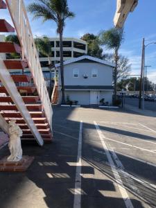 a street with a staircase and a building and palm trees at 777 Motor Inn in Sherman Oaks