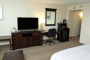 a hotel room with a desk with a television and a bedroom at Holiday Inn Birmingham-Airport, an IHG Hotel in Birmingham
