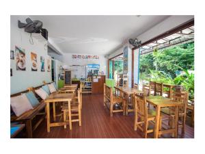 a restaurant with wooden tables and chairs at Namhasin House in Ko Tao