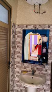 baño con lavabo y espejo en la pared en superb house in the heart of the mountains, en Bine el Ouidane