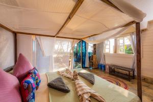 a bedroom with a large bed with a canopy at Simrose in Agonda