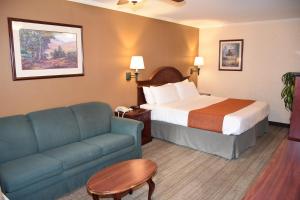 a hotel room with a bed and a couch at Dynasty Suites Redlands in Redlands
