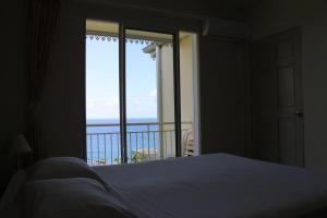 a bedroom with a bed and a view of the ocean at La Fournaise Hotel Restaurant in Sainte-Rose