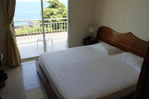 una camera con letto e vista sull'oceano di La Fournaise Hotel Restaurant a Sainte-Rose