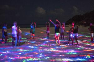 a group of people standing on a beach with lights at Sea View Villa Ukulhas in Ukulhas