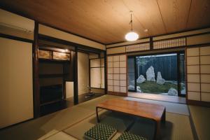 京都的住宿－七条みやび Nanajo Miyabi Inn，客房设有木桌和窗户。