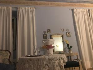 einem Esstisch mit einem Spiegel und einem Tisch mit einem weißen Tischtuch in der Unterkunft Palazzo De Fabritiis in Rosciano