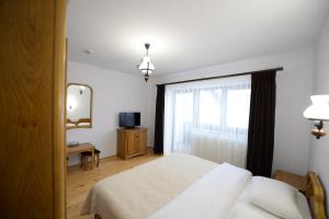 1 dormitorio con cama y ventana en PENSIUNEA ARINAS en Vatra Dornei