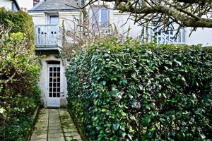 a hedge in front of a house with a door at Pegase in Deauville