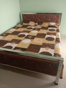 a bed with a quilt on top of it at Woodland Lodge and Restaurant in Guwahati