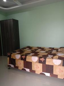 Un dormitorio con una cama con una manta. en Woodland Lodge and Restaurant, en Guwahati