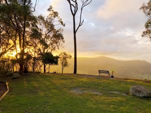 a park bench on a hill with a view of the mountains at Valley View Luxury Retreat in Vacy