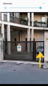 a gate with a yellow arrow on it next to a building at Home Sweet Home COSENZA in Cosenza