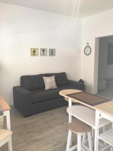 a living room with a black couch and a table at Maxorata Town Fuerteventura in Morro del Jable