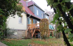une maison avec une terrasse sur le côté dans l'établissement Ferienwohnung Apartement am Wolfsberg, à Reinhardtsdorf