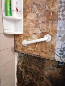 La salle de bains est pourvue d'un mur en pierre et d'un réfrigérateur. dans l'établissement casa nica sul mare house on the sea, à Cefalù