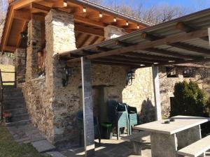 eine Terrasse mit einer hölzernen Pergola und einem Tisch in der Unterkunft B&B RONCHI in Castelrotto