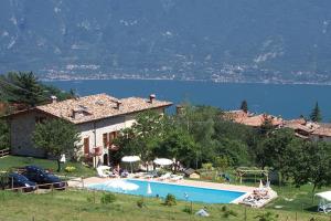 a house with a swimming pool in front of a lake at Casale di Pegol in Tignale