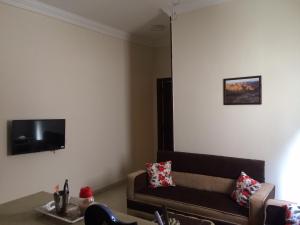 a living room with a couch and a tv on the wall at Lady Queen Apartment in Marsa Alam City