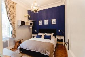 Un dormitorio con una cama con paredes azules y una lámpara de araña. en Bordeaux Saint André - elegant, central and quiet, en Burdeos